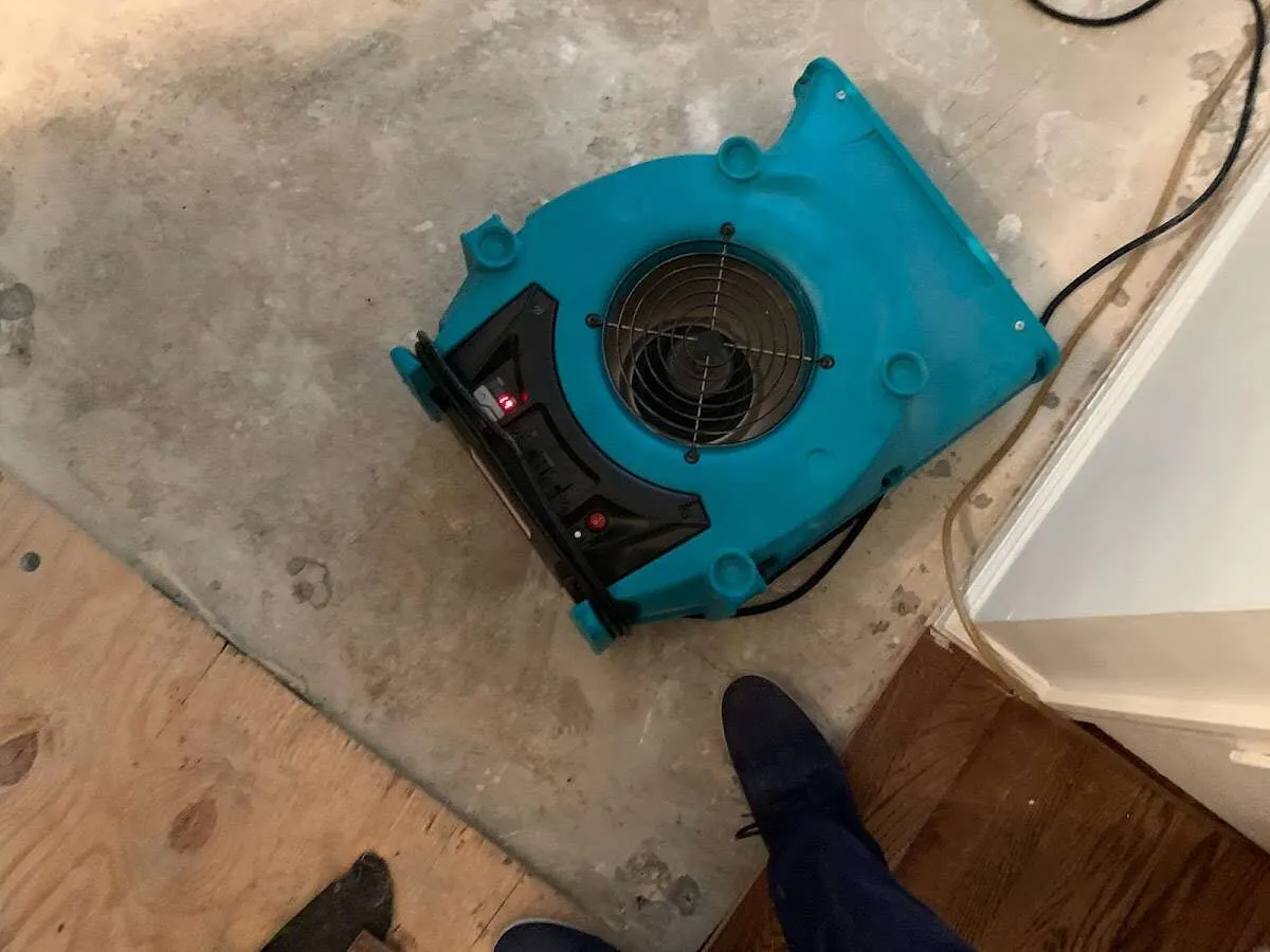 Air mover drying subfloor during Commercial Water Damage Restoration in Salt Lake City